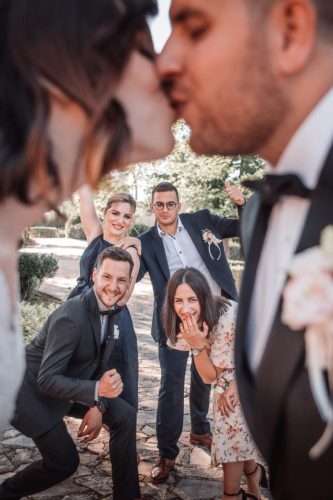 fotograf vjenčanja Kvarner - fotografija para tijekom vjenčanja s gostima u pozadini valorem media